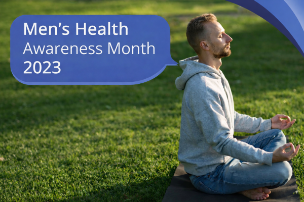 A man sits cross-legged on a yoga mat in a sunny green field, meditating with his hands resting in a relaxed pose. A blue speech bubble in Open Sans reads “Men’s Health Awareness Month 2023,” with curved blue brand accents in the top-right corner and no logo present.