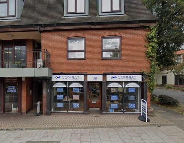 Front street-level photo of a brick commercial building with Connect-branded shopfront windows and signage, used as an ‘About Us’ header image to represent the company’s local office presence.
