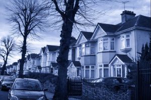 Row of traditional UK terraced houses on a residential street with a blue-tinted overlay, representing properties suitable for Buy-to-Let Portfolio Mortgages.